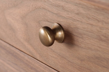 ウォールナットの素材感をさりげなく高める上品で丈夫な真鋳つまみ。